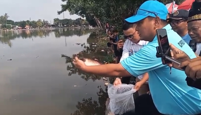 Ketua Komisi B DPRD Kota Depok dari Fraksi Gerindra, H. Hamzah saat melakukan pelepasan simbolis ikan mas sekitar tiga kilogram di Situ Cilodong, Minggu (7/12). 